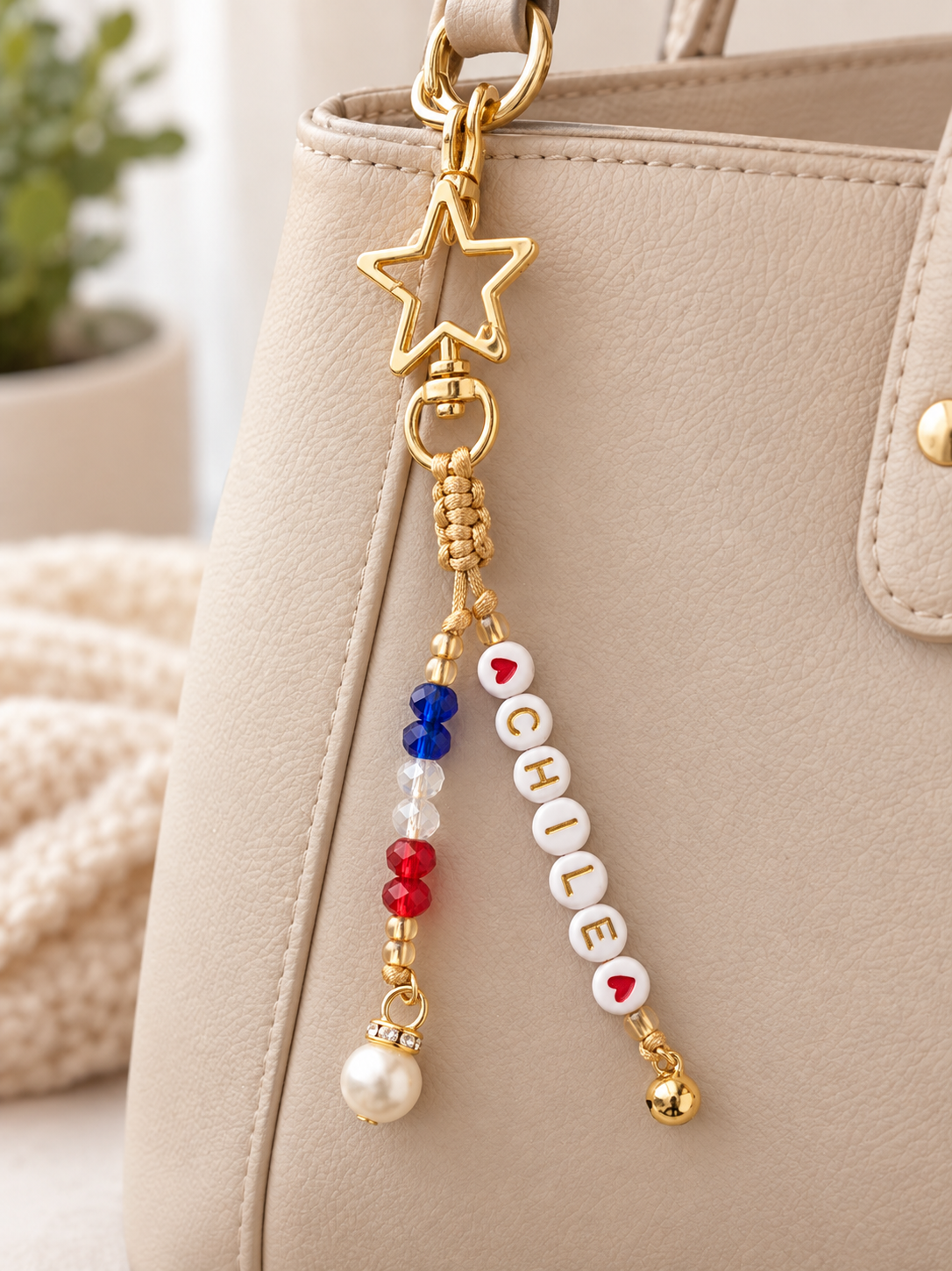 Llavero dorado con mosquetón en forma de estrella, cuentas con la palabra Chile entre corazones, cristales en azul, blanco y rojo.