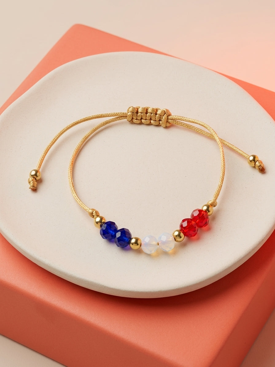 Pulsera artesanal ajustable en hilo dorado con cristales en los colores de la bandera de Chile (azul, blanco y rojo) y balines dorados. Elegante, liviana e ideal para regalar.